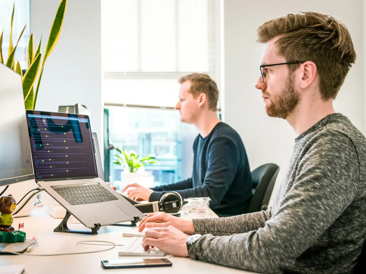 Two people working at their desks in a bright office